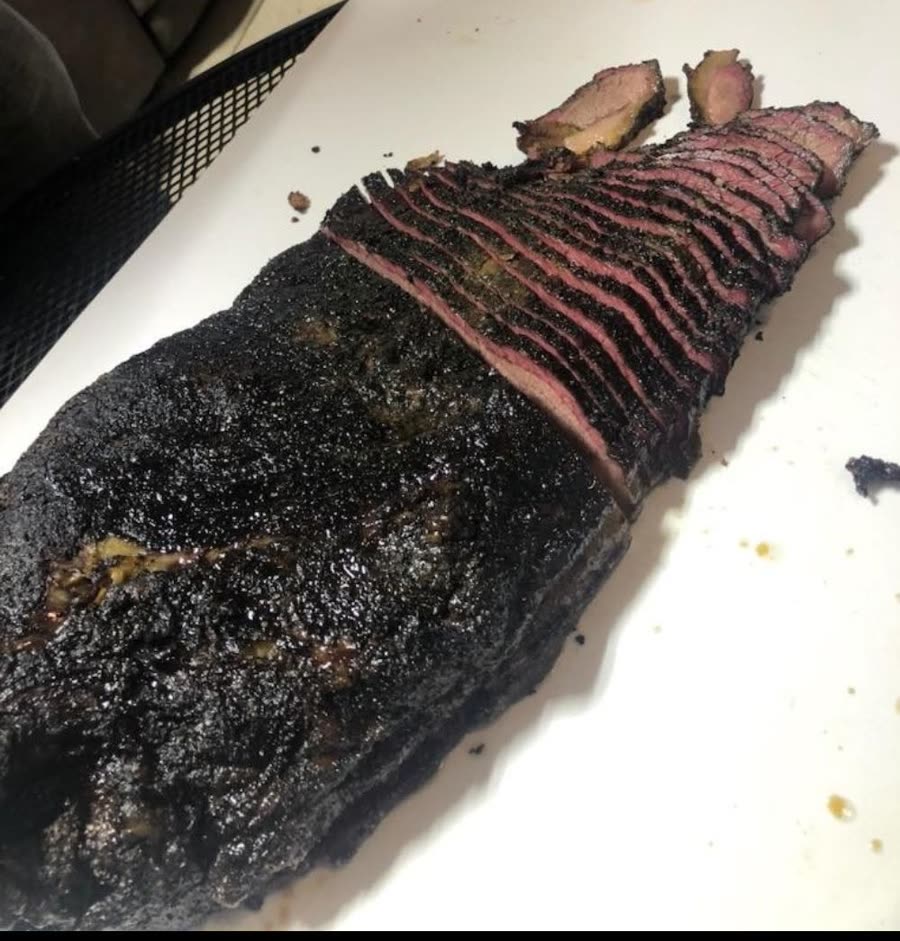 Sliced smoked brisket with a dark bark, fresh off the smoker