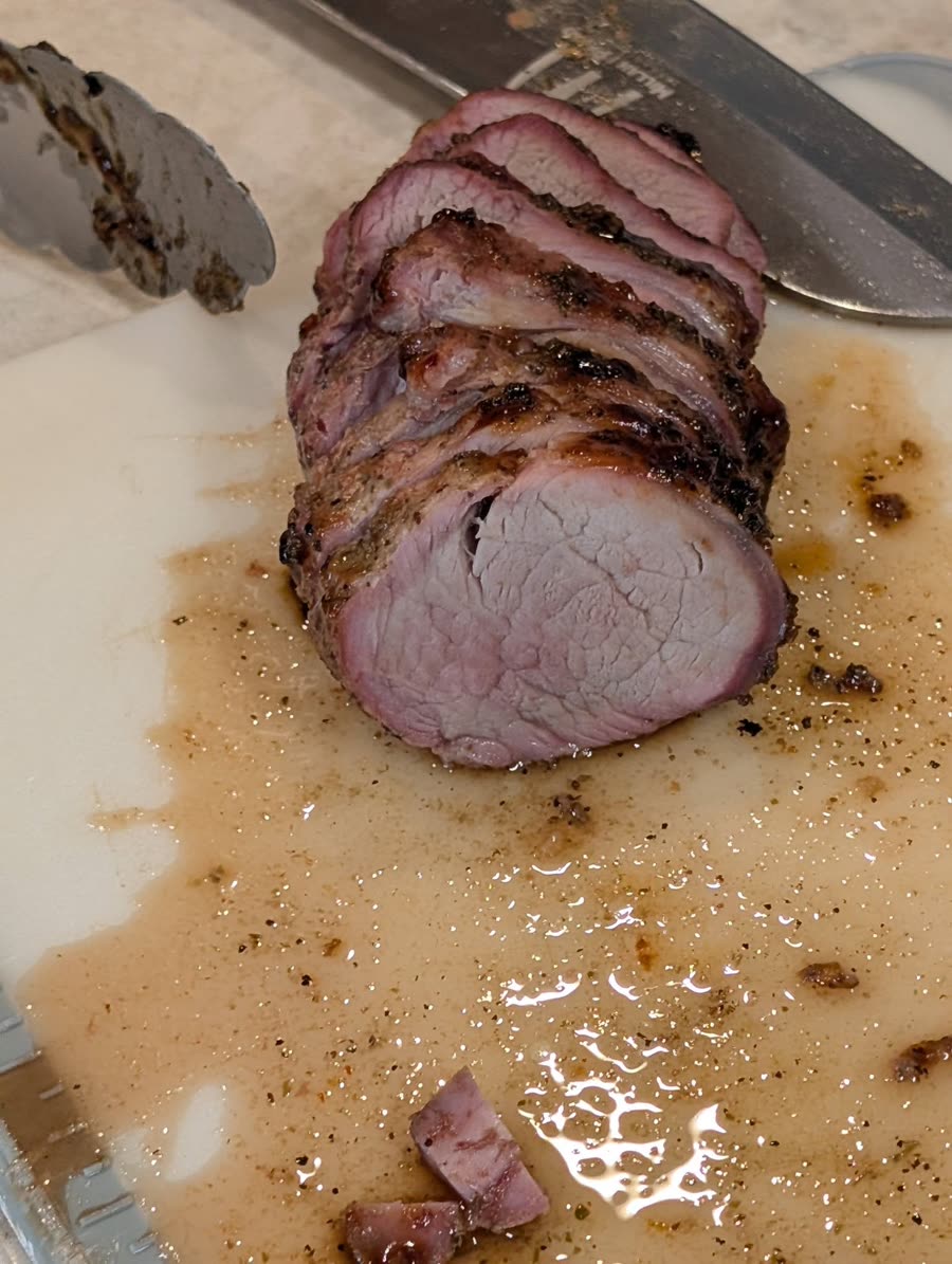 Sliced smoked pork tenderloin on a cutting board
