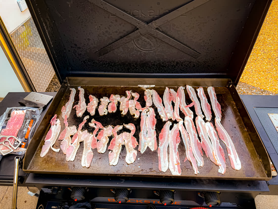 Bacon frying on the griddle for a wedding morning brunch