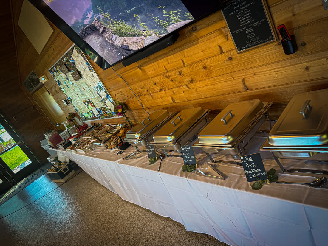 Brunch buffet spread with chafing dishes, pastries, and hand-lettered menu signs